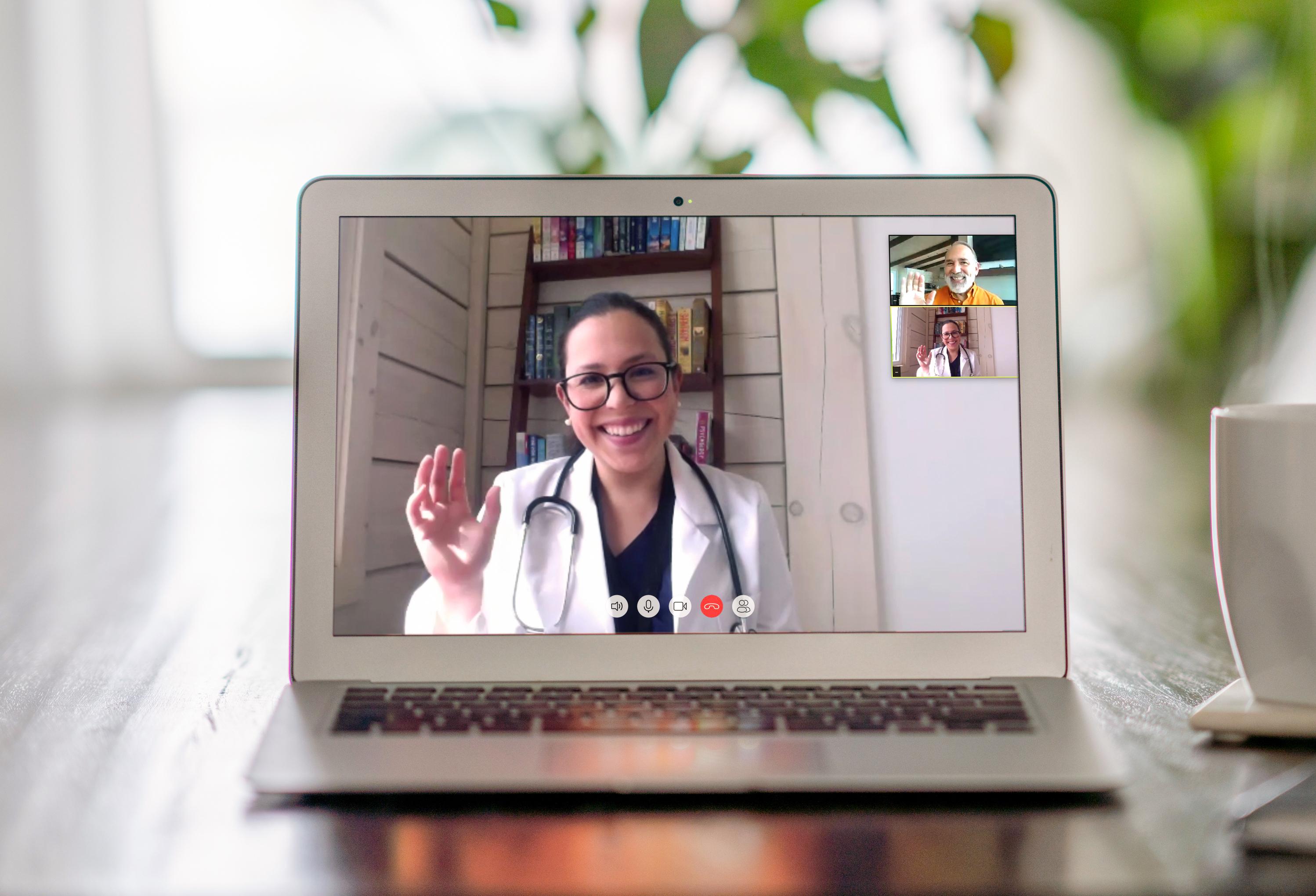 A laptop is on a table and shows a customer on a video call with a vet doctor. There is a cup of coffee beside the laptop.